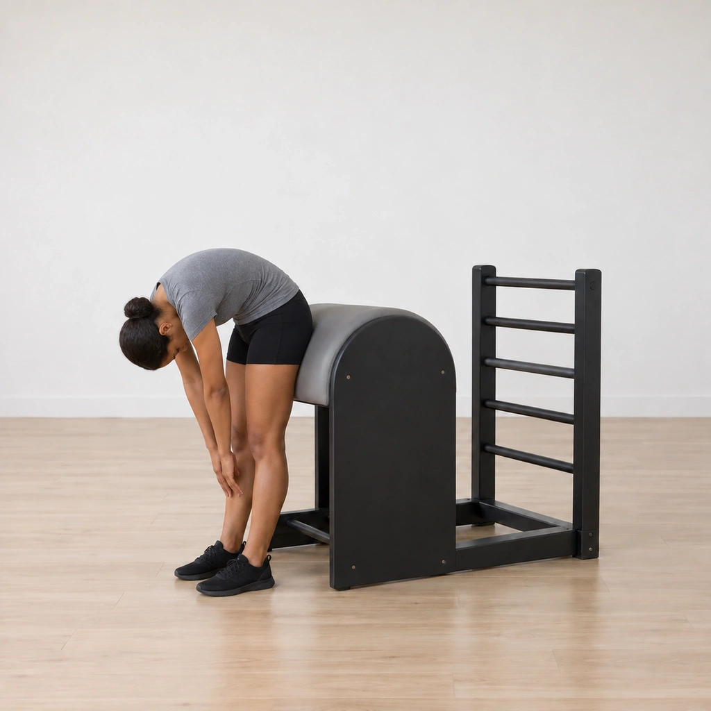 She has rolled up and is rounding forward, arms reached between her legs toward the floor.