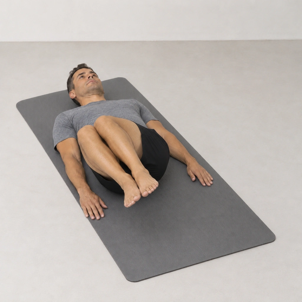 The same man lying on his back, his raised knees, still together, now drifted to his right side while his back stays flat on the mat.