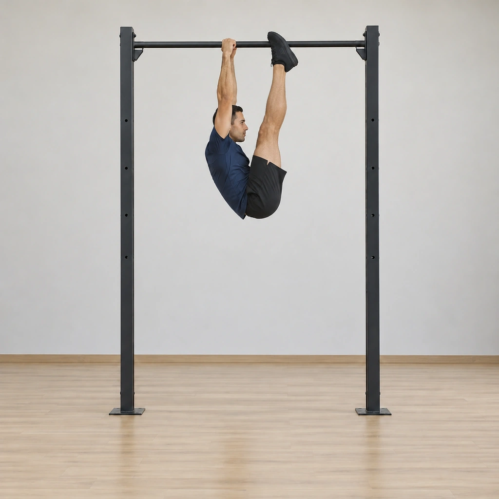 He reaches the top: straight legs extended fully upward so the toes touch the bar between his hands, hips piked high, body folded tight against the bar line, arms extended.