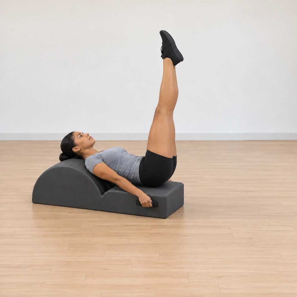 Her legs point up toward the ceiling above her hips, still long and together, her head at the barrel, her hands on the handles and her shoulder girdle grounded.