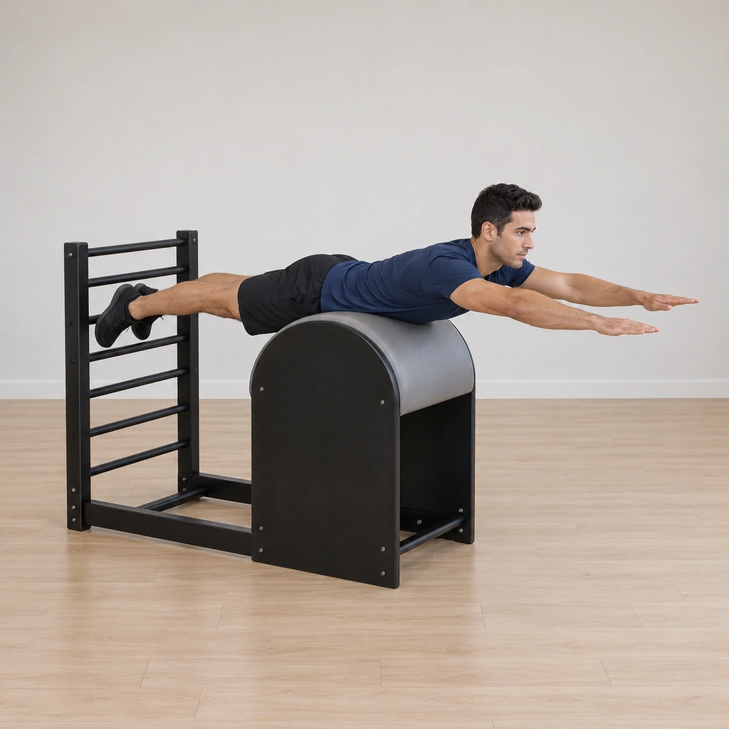 A man lies prone on the barrel apex - hips at one end, chest at the other, arms reached forward, legs long behind.