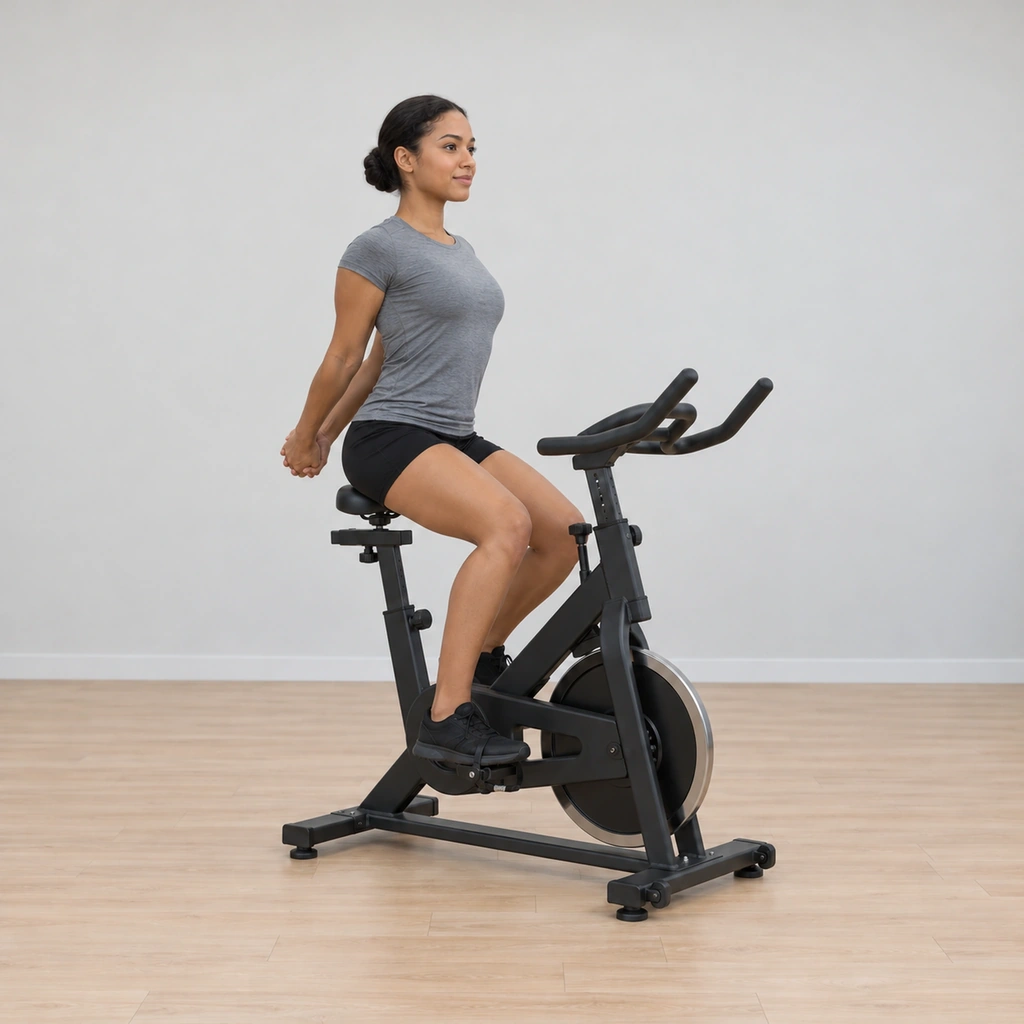 She sits tall on the saddle, both hands clasped behind her back and her chest opened forward, feet resting easy on the pedals.