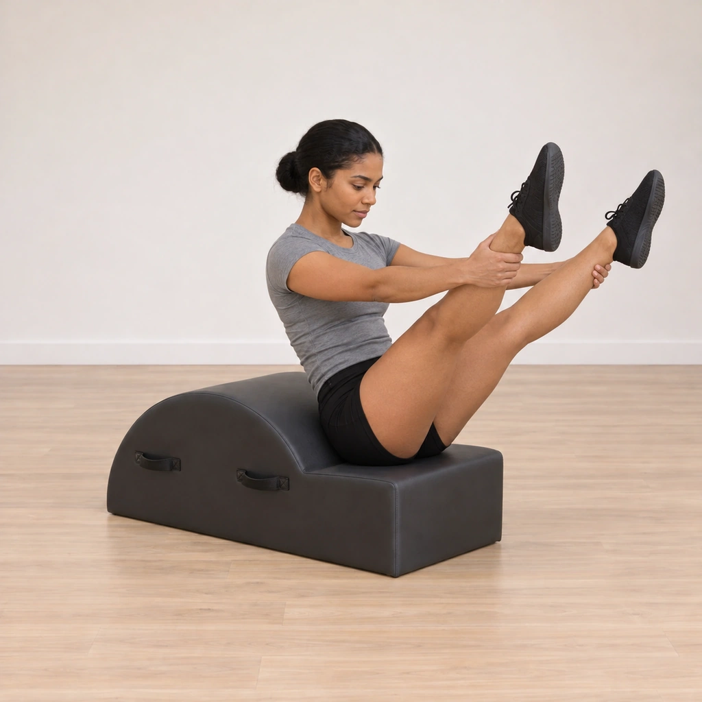 Her legs are reached forward toward straight in a wide V, arms straight holding the ankle fronts, spine tall, her gaze between her shins.