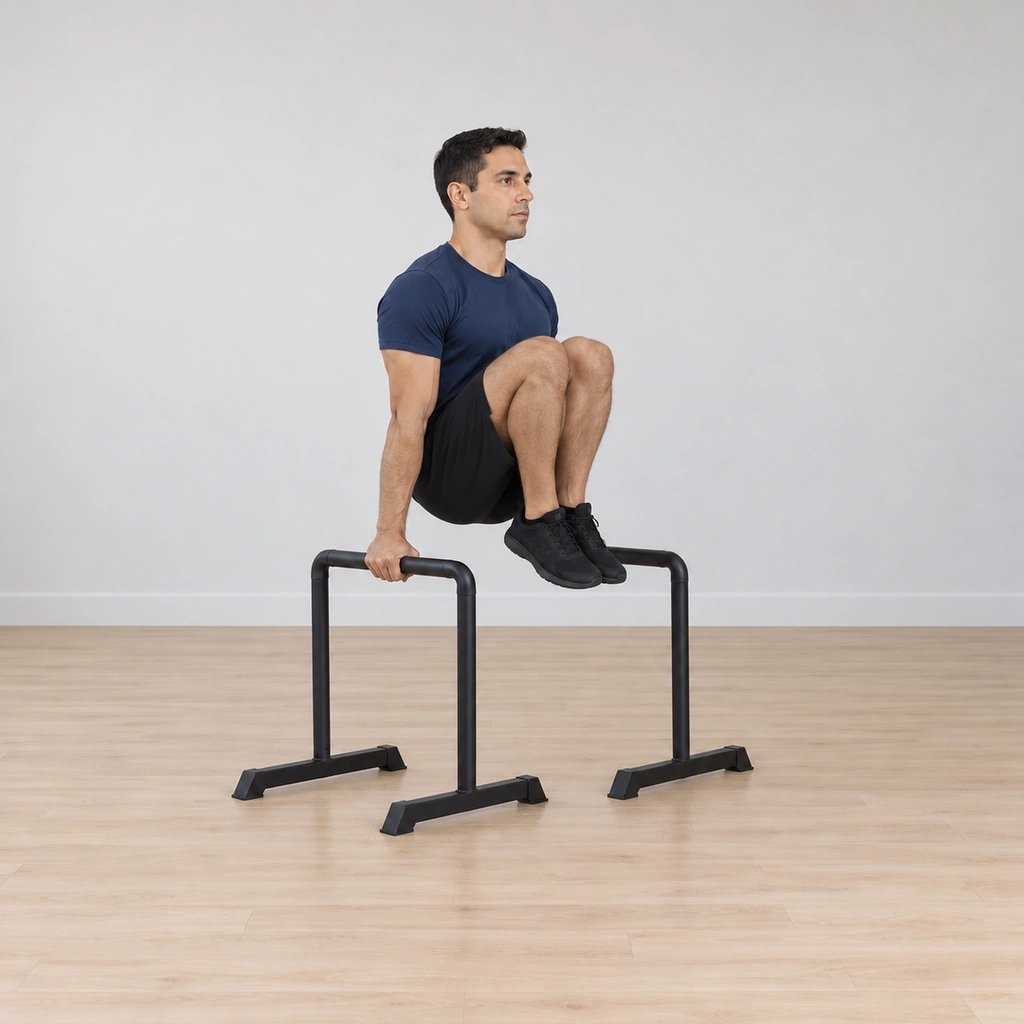 He holds both knees pulled fully to his chest, arms locked straight, feet tucked under him clear of the floor.