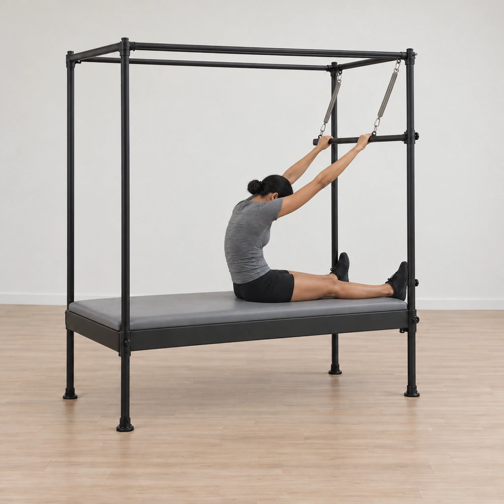 Her spine has begun articulating back toward the table behind her, her arms still long and straight holding the lifted bar, her feet still pressed into the poles.