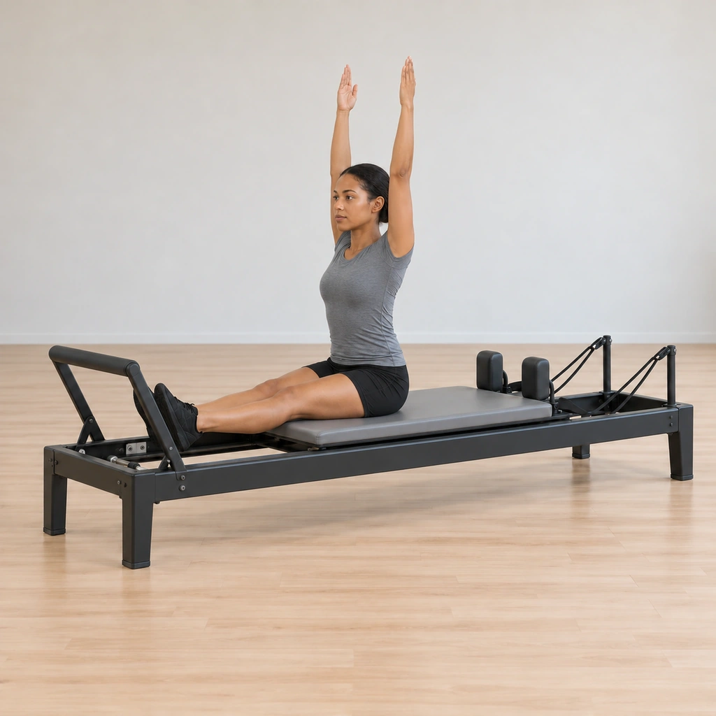 Her torso has lifted as both arms stretch straight up to the ceiling, the spine elongating, the carriage held still.
