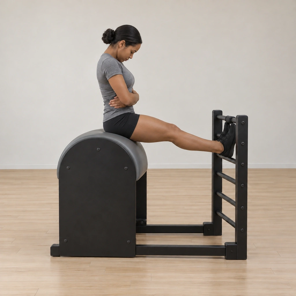 She is articulating back up through the spine with the chin held toward the chest, arms still wrapped, returning to the seated start.