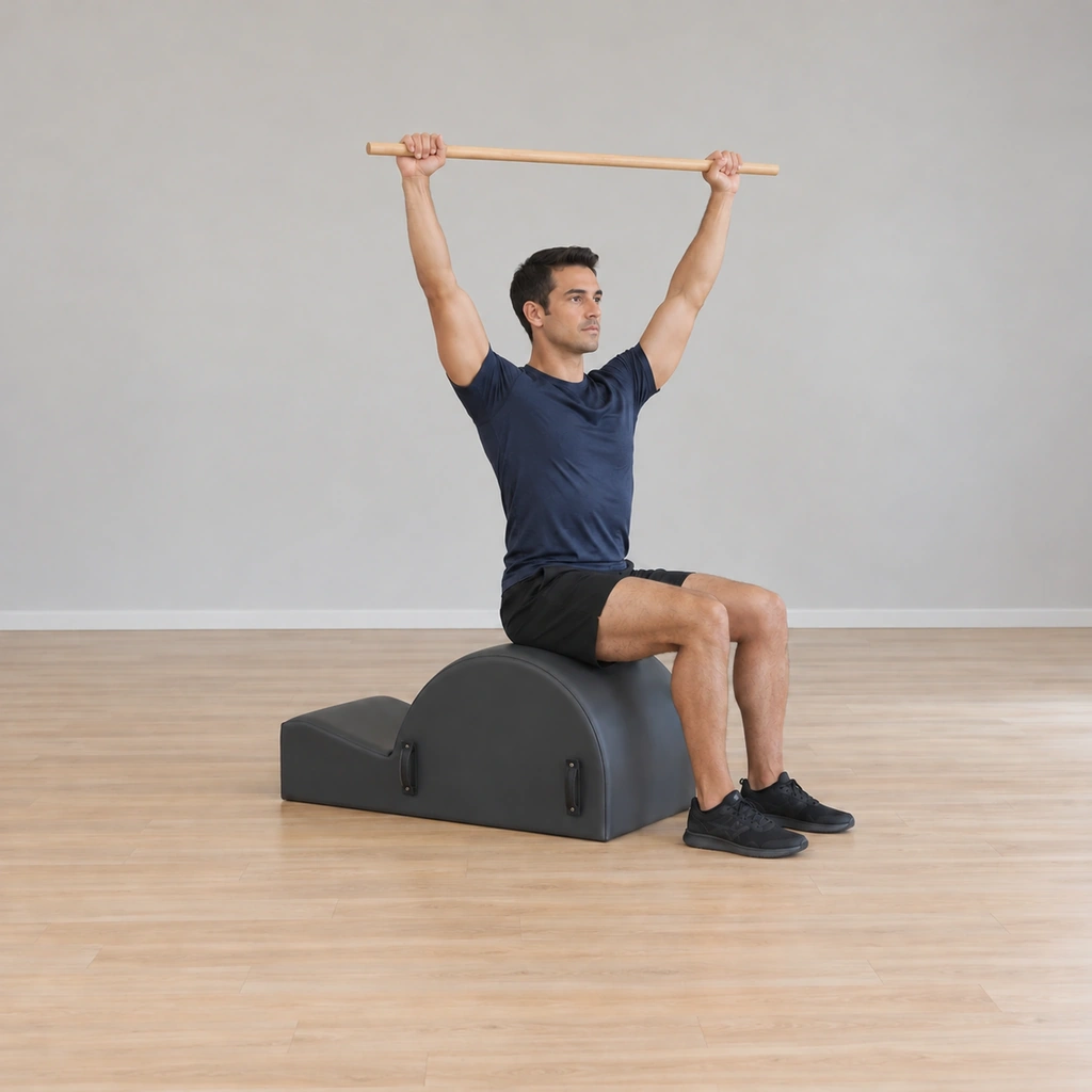 He is lifting back toward tall with the twist still held; at the top the torso unwinds back to square, the pole overhead.