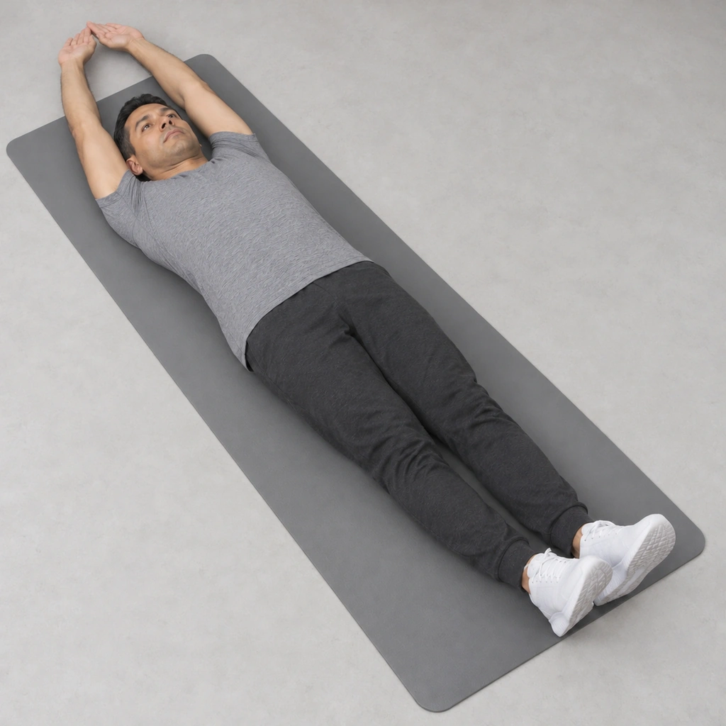 The same man lying face-up, both straight arms now extended overhead beyond his head, close to the mat, the two thumbs touching each other.