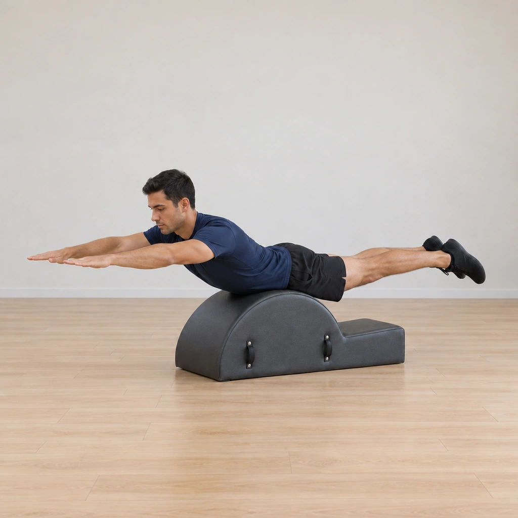 The man returns both lifted limbs to the level extension line, chest and legs held evenly above the floor, thighs clear of the barrel, still balanced on the arc apex.