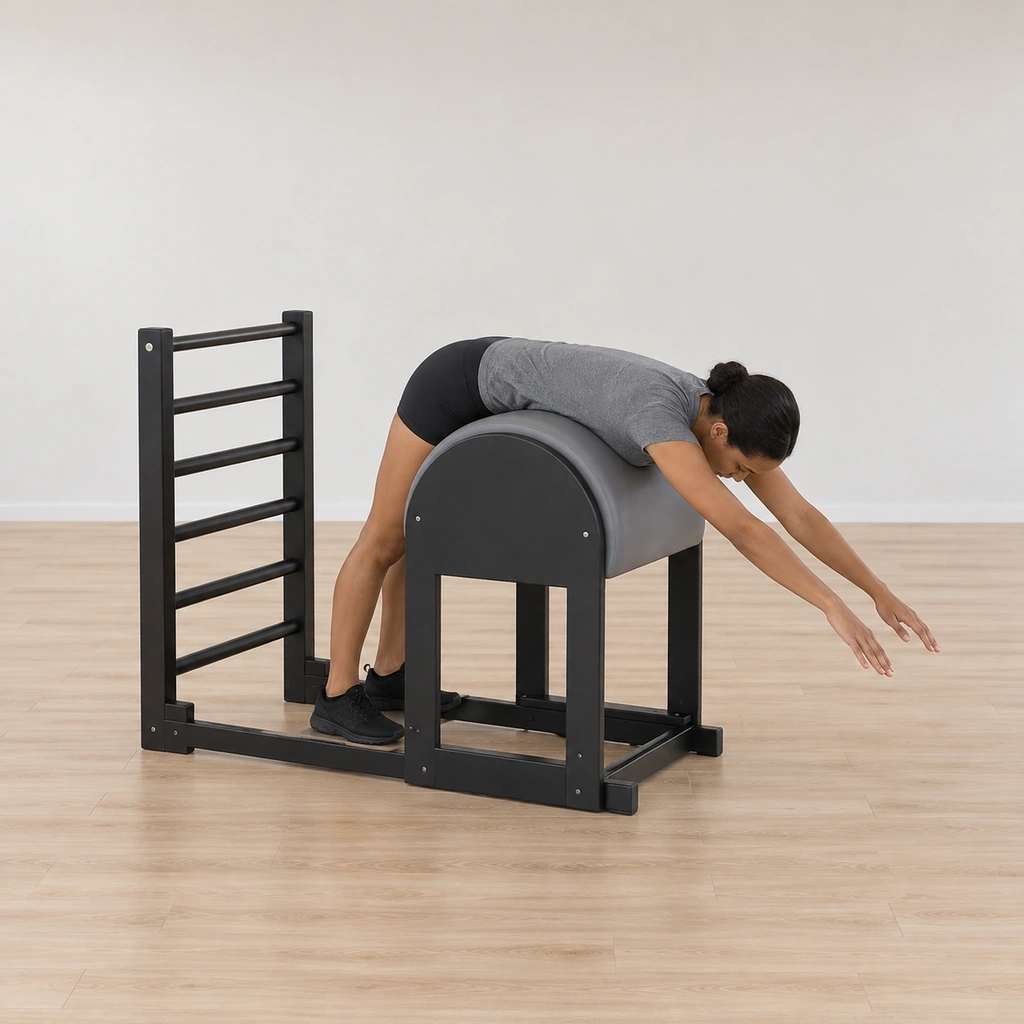 A woman stands inside the ladder barrel, feet on the frame base, hips on the barrel, torso draped over the apex with her arms reaching long from her upper back.