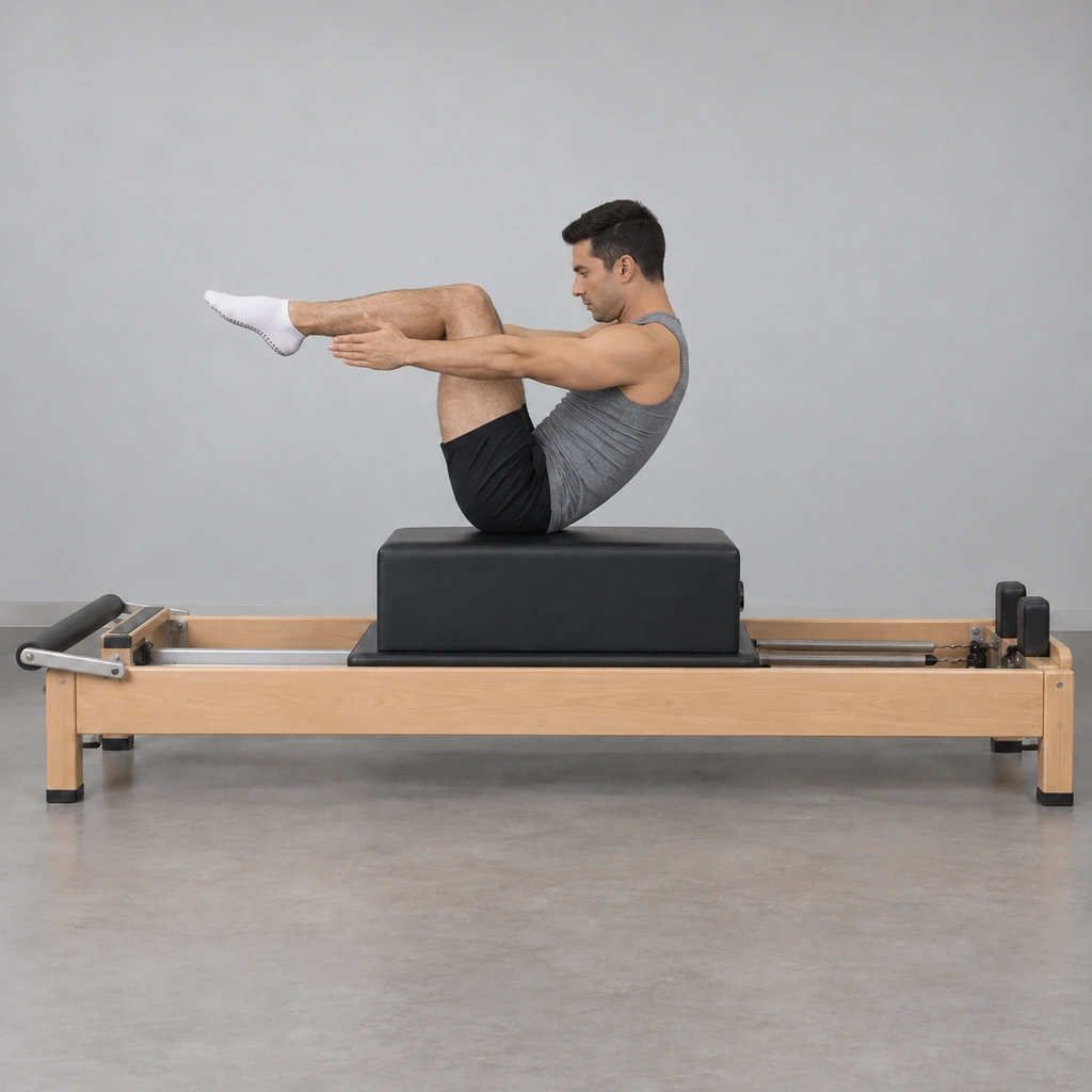 The same man now sitting up on the long box, spine curved, both arms reaching forward, knees still bent.